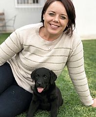 The breeder sitting with a puppy